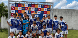Equipo infantil de la Escuela Alfredo Maldonado celebra su título de fútbol junto al trofeo y sus medallas.