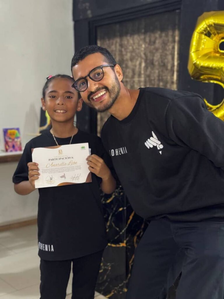 Anarella Le&oacute;n posa junto a su instructor con un certificado de participaci&oacute;n