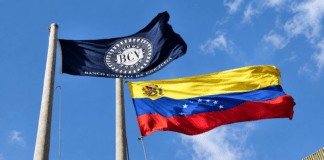 Banderas del Banco Central de Venezuela y Venezuela ondeando frente al edificio del BCV