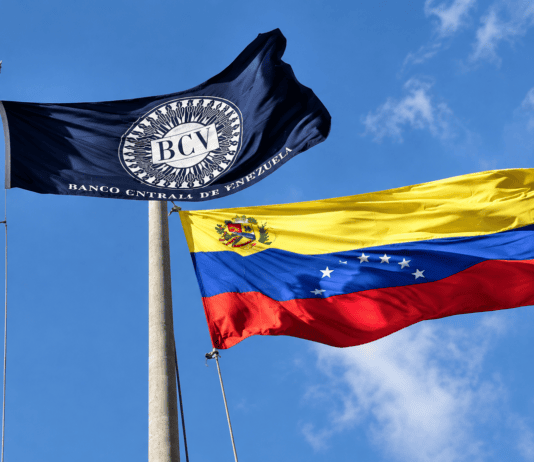 BCV eleva tasas de interés y establece remuneración para todos los depósitos bancarios Banderas del Banco Central de Venezuela y Venezuela ondeando frente al edificio del BCV