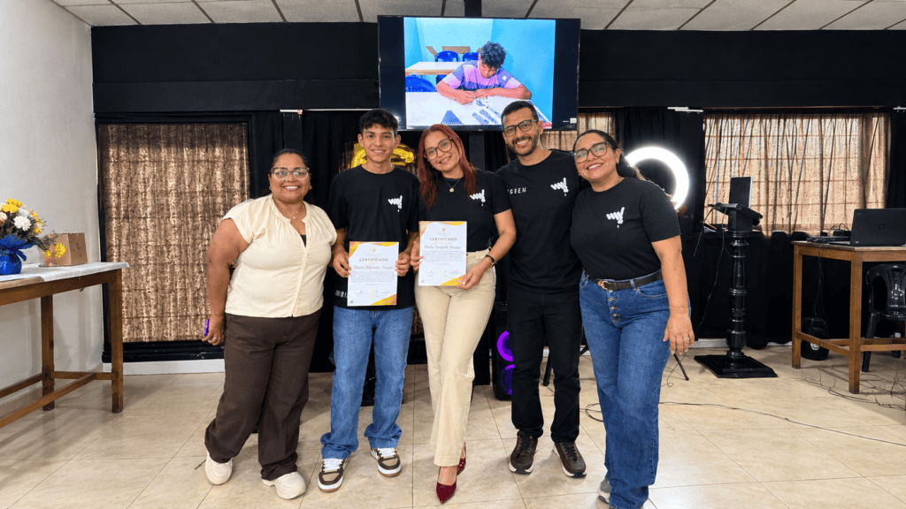 Peter Parra y Stephany Mej&iacute;as sostienen sus certificados junto al equipo docente