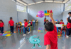 Niños de preescolar participan en actividades dentro de un aula escolar junto a una docente.