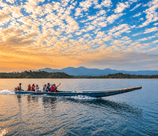 Porturismo dictará conversatorio gratuito “Negocios con Destino” este viernes en Araure Personas realizan un paseo en lancha por un lago al atardecer, con montañas al fondo.