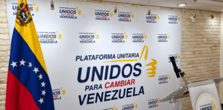 Escenario de rueda de prensa de la Plataforma Unitaria con bandera de Venezuela y atril institucional