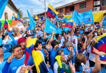 Banderas de Venezuela y estandartes azules de Vente Venezuela ondean durante una concentración política en el estado Portuguesa.