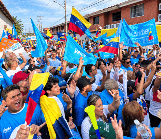 Banderas de Venezuela y estandartes azules de Vente Venezuela ondean durante una concentración política en el estado Portuguesa.
