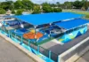 Vista aérea de la cancha deportiva techada El Esfuerzo, con superficie multicolor, gradas y estructura de techo azul, en Villa Araure.