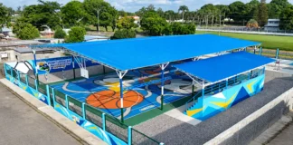Vista aérea de la cancha deportiva techada El Esfuerzo, con superficie multicolor, gradas y estructura de techo azul, en Villa Araure.