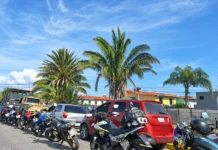 Fila de vehículos y motocicletas detenidos en una vía durante la espera para abastecerse de combustible.