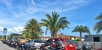 Fila de vehículos y motocicletas detenidos en una vía durante la espera para abastecerse de combustible.