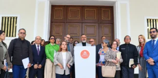 Giuseppe Alessandrello se dirige a los medios desde un podio de la Asamblea Nacional, acompañado por integrantes del Comité de Postulaciones Judiciales en el Palacio Federal Legislativo.