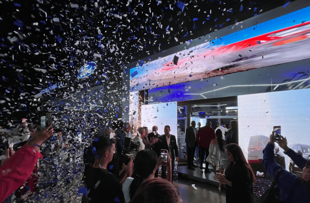 Directivos e invitados aplauden bajo una lluvia de confeti azul y blanco durante la inauguración de Motores Oshima.