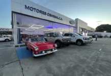 Fachada de Motores Oshima en Acarigua con un Ford Thunderbird clásico, una Bronco y una pickup F-150 en exhibición.