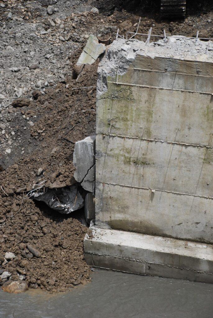 Detalle del estribo de concreto fracturado y las fundaciones expuestas tras el colapso del puente de Ospino.
