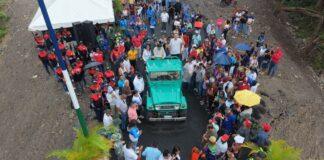 Autoridades y habitantes participan en el corte de cinta durante la inauguración del puente sobre el río Ospino.