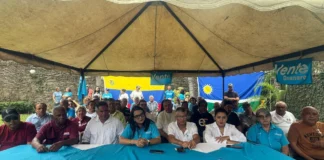 Dirigentes y simpatizantes de Vente Venezuela reunidos bajo una carpa durante una rueda de prensa en Guanare, con banderas de Venezuela y de la organización política al fondo.