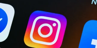 Persona sosteniendo un teléfono móvil con iconos de distintas redes sociales, incluido Instagram.