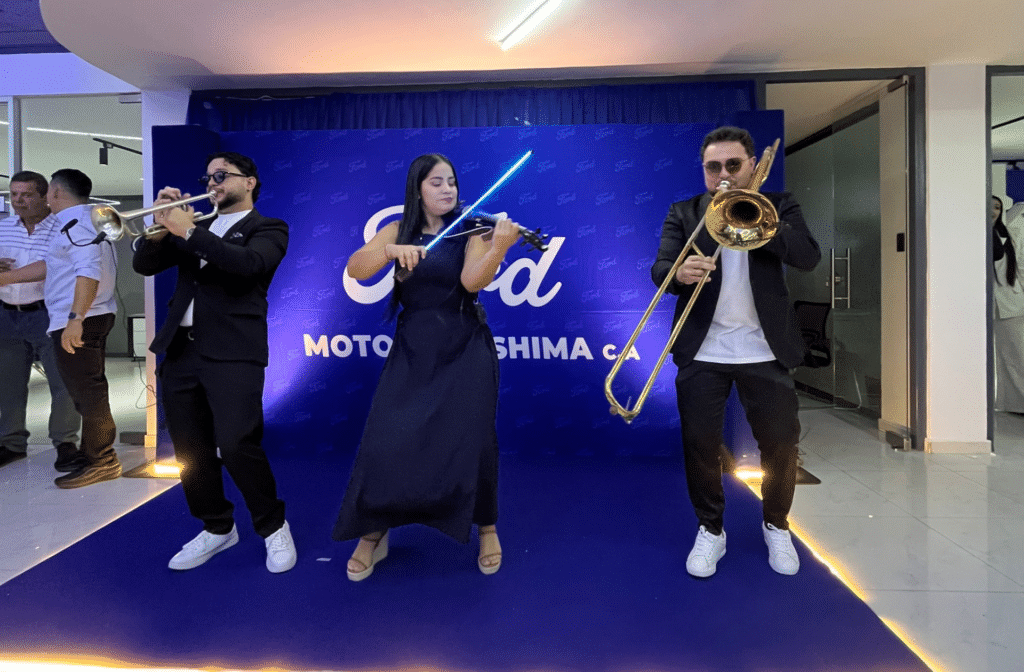 Trío musical interpreta melodías en vivo durante el cóctel de inauguración de Motores Oshima en Acarigua.